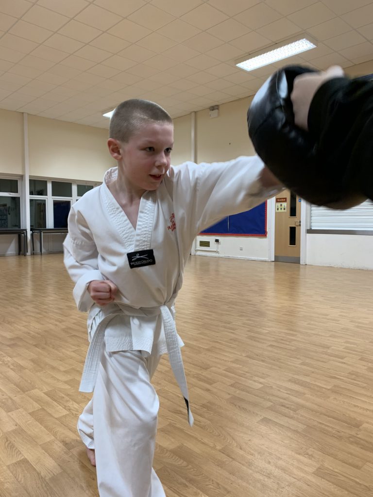 MPowered MA Junior punching a pad during a junior martial arts session